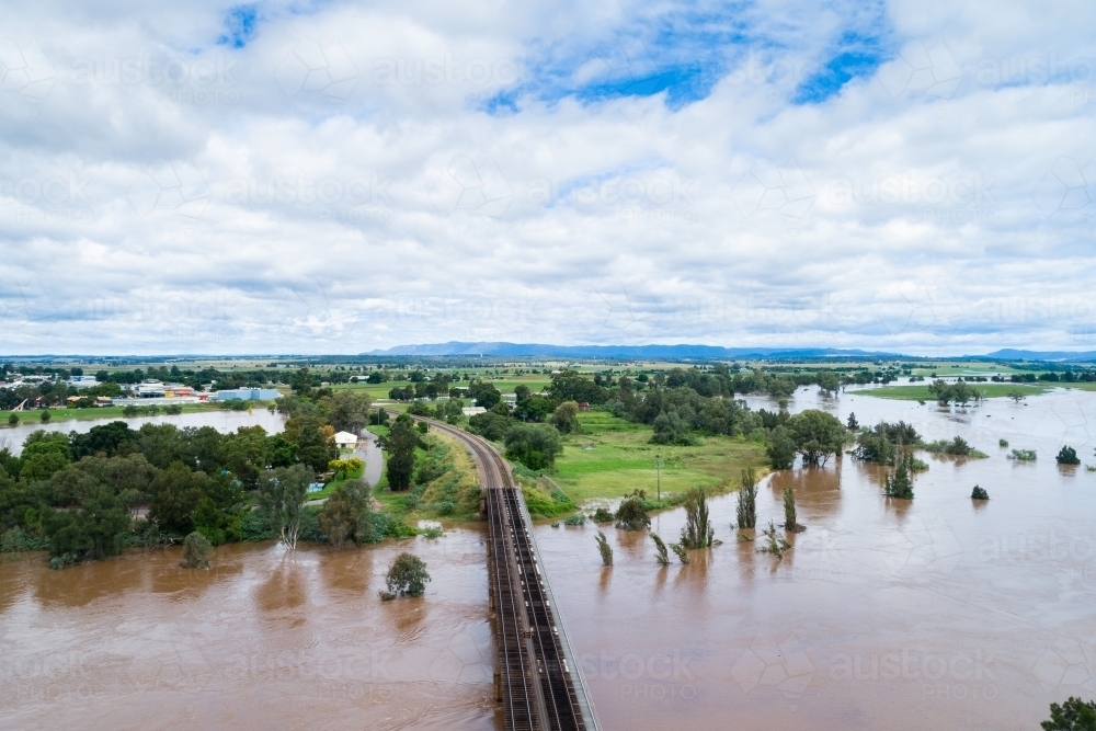 Railway line bridge over flooding Hunter River near Singleton during flood - Australian Stock Image