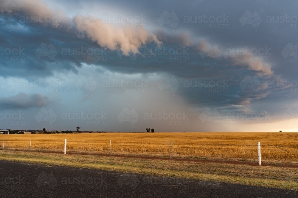 Rain falling from a dramatic stormfront over rural farmland - Australian Stock Image