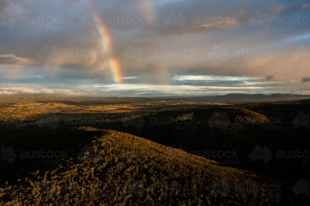 Rainbow over granite belt landscape - Australian Stock Image