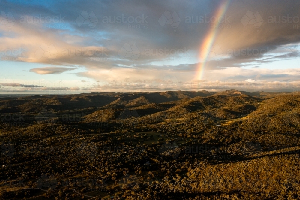 Rainbow over granite belt mountain landscape - Australian Stock Image