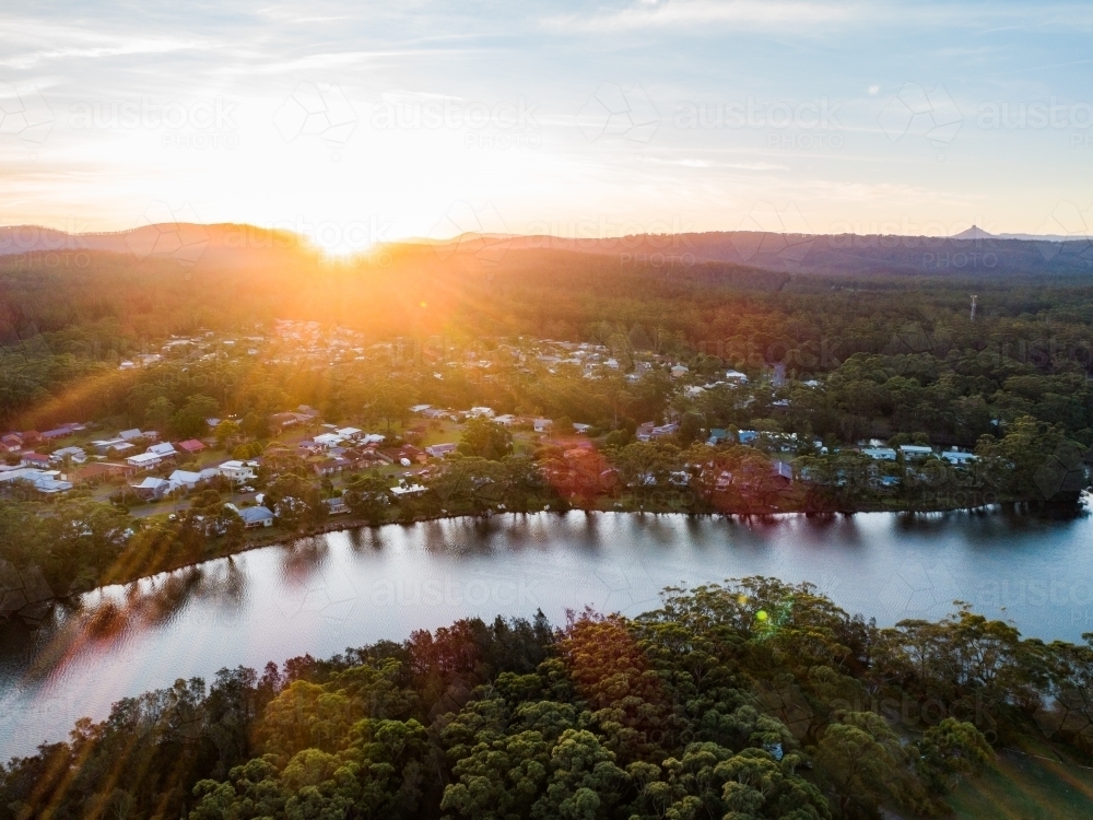 Rays of sunlight over a river edged in trees - Australian Stock Image