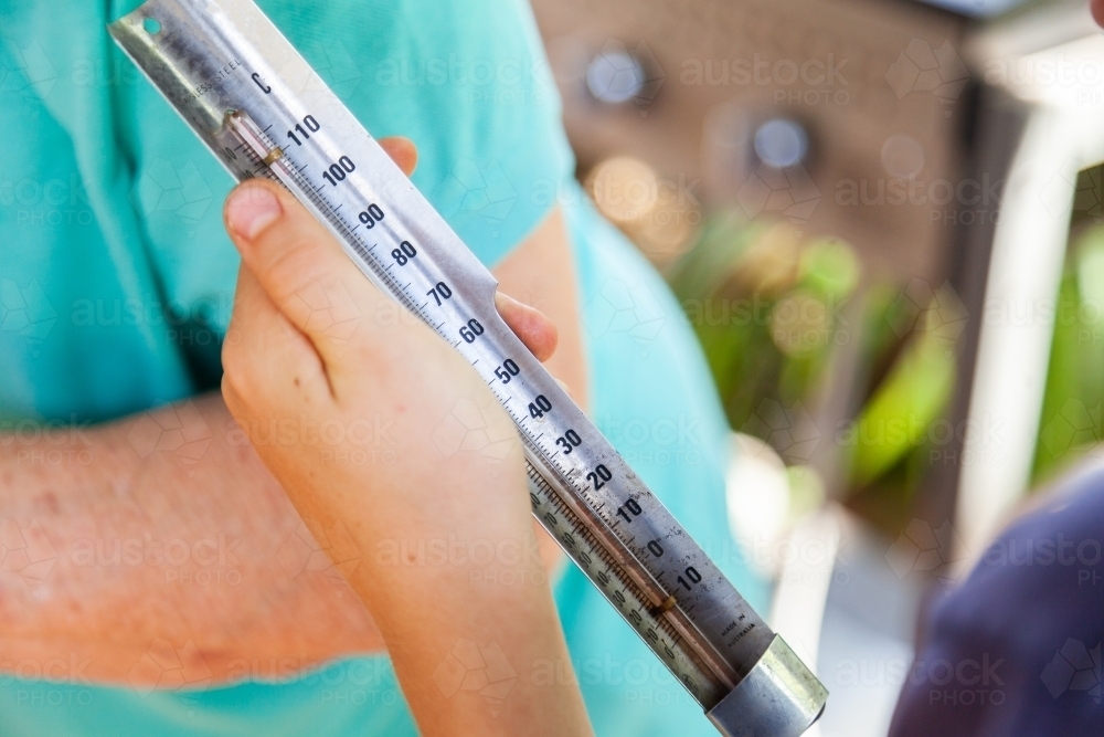 Reading temperature on thermometer - Australian Stock Image