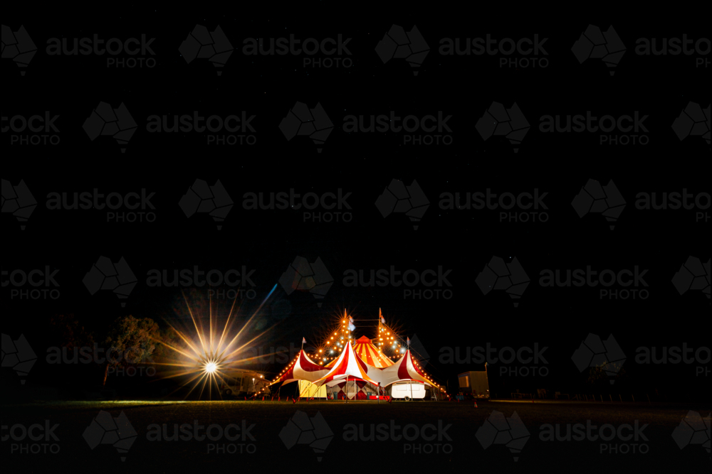 Red and white big top circus tent visiting small town in rural Australia illuminated at night - Australian Stock Image