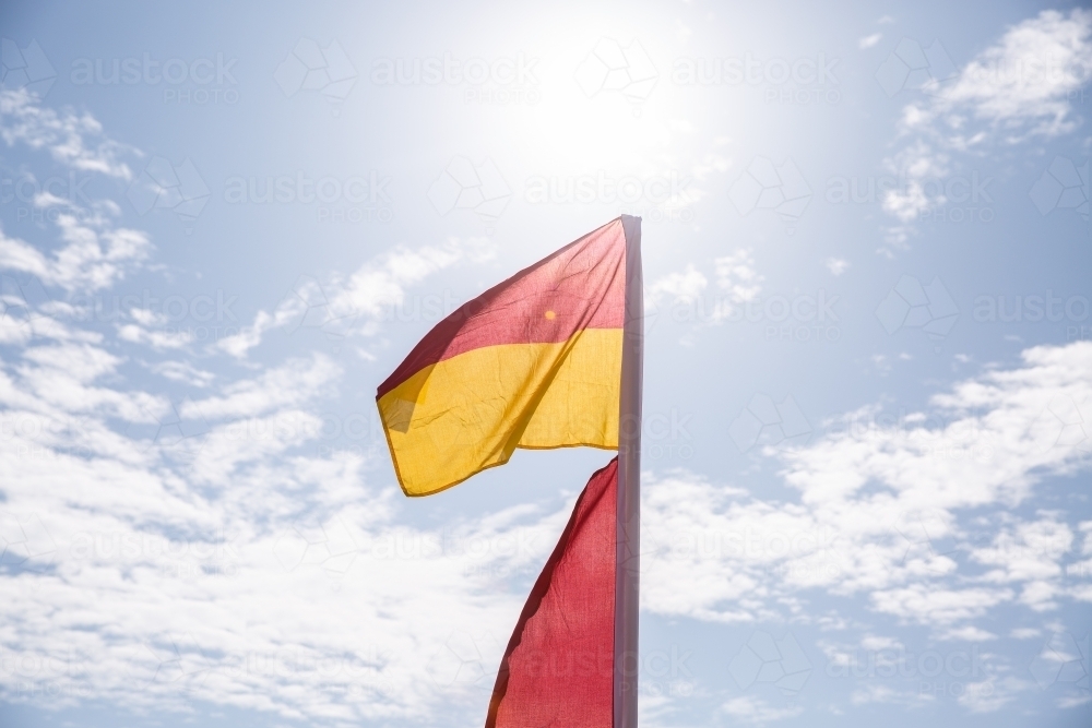 red and yellow flag with the sun behind - Australian Stock Image