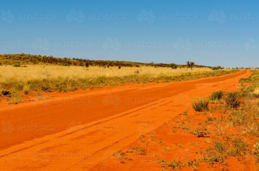 Red sandy road through the desert - Australian Stock Image