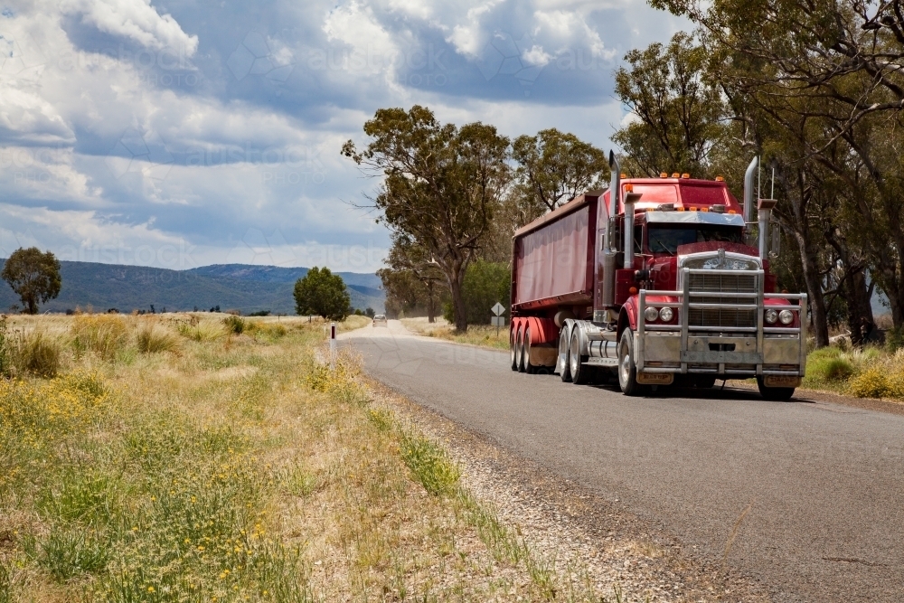 Red truck on rural country road - Australian Stock Image