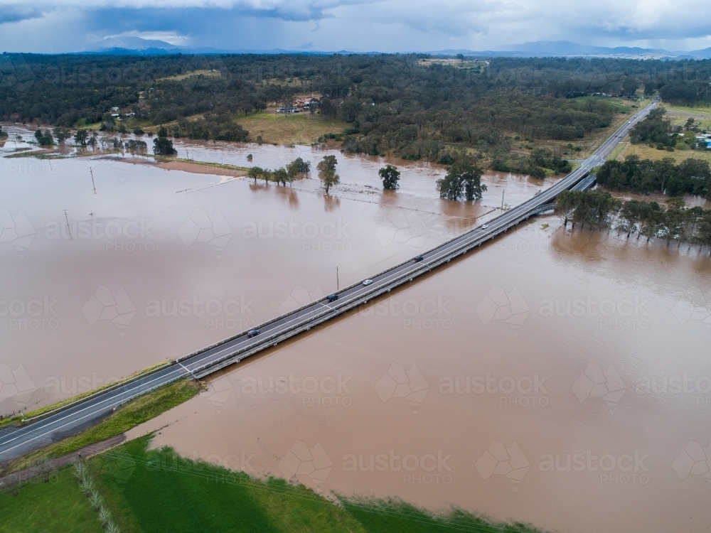 Redbournberry bridge near Singleton surrounded by floodwater during natural disaster of flood - Australian Stock Image