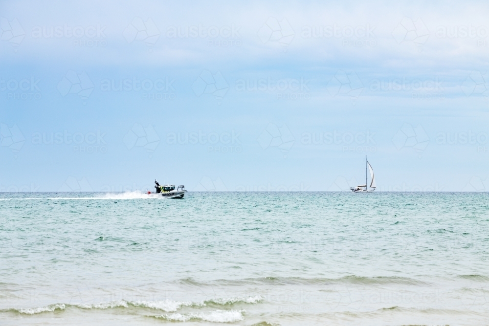 Rescue boat patrolling along beach - Australian Stock Image