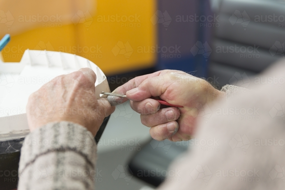 Retired Man's hands working on model boat - Australian Stock Image