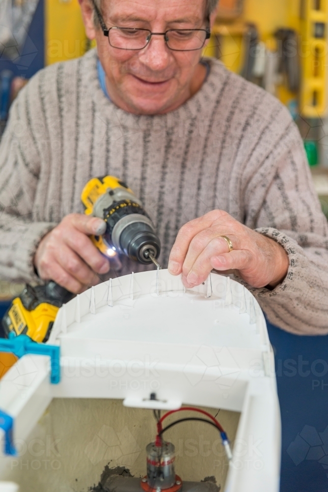 Retired Man (White) Smiling Working On Model Boat - Australian Stock Image