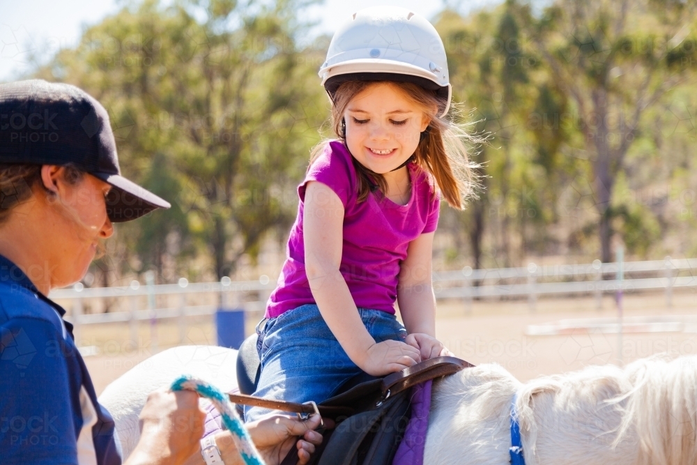 Riding instructor teaching young rider how to ride horse - Australian Stock Image