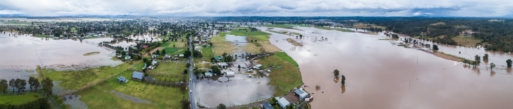 River with broken banks during flood with floodwater covering farmland - Australian Stock Image