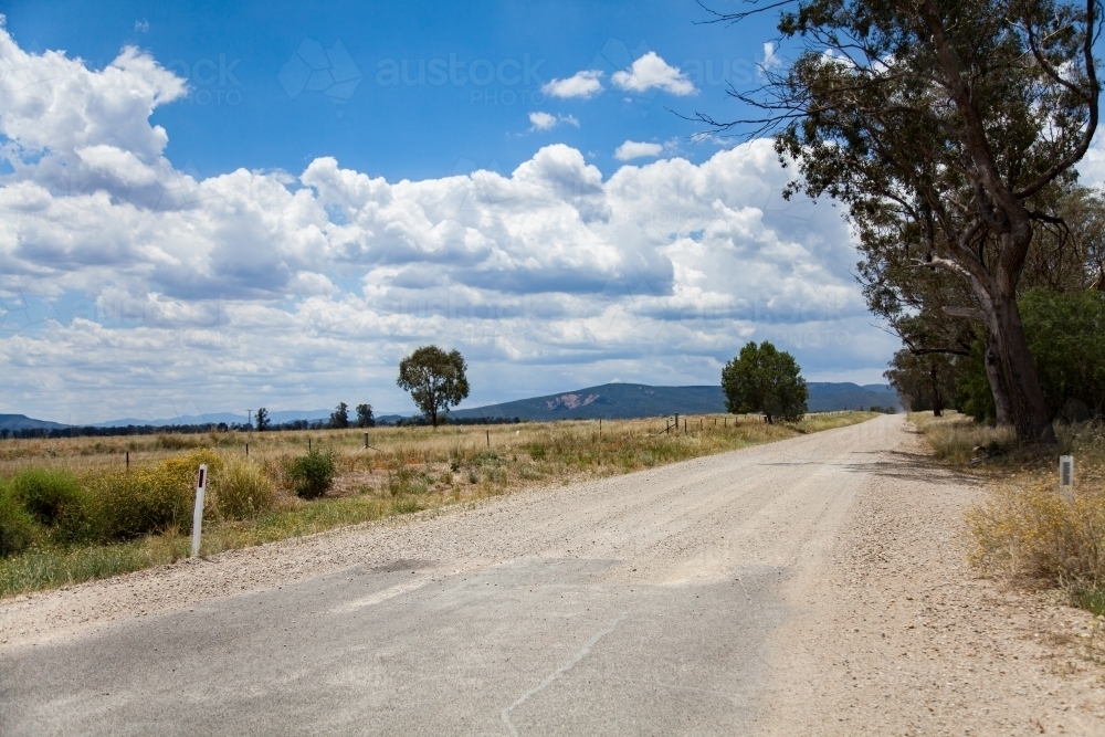 Road changing from sealed to unsealed gravel country dirt road - Australian Stock Image