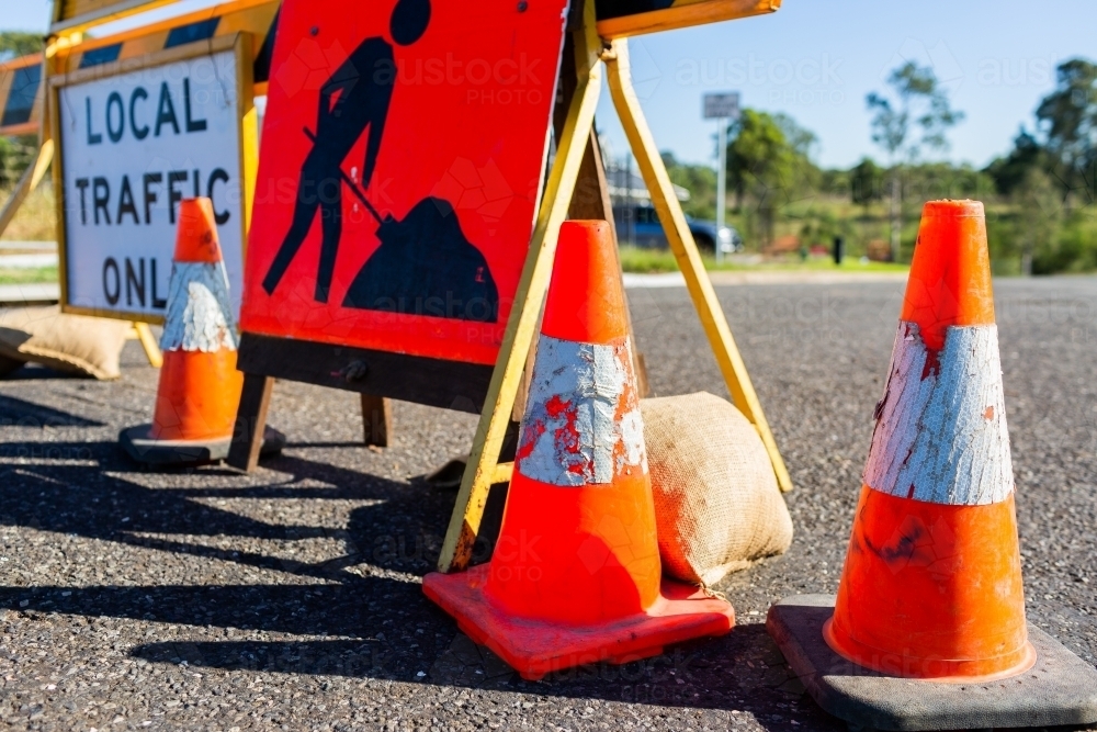 Road closed local traffic only sign with witches hat cones for roadwork resurfacing - Australian Stock Image