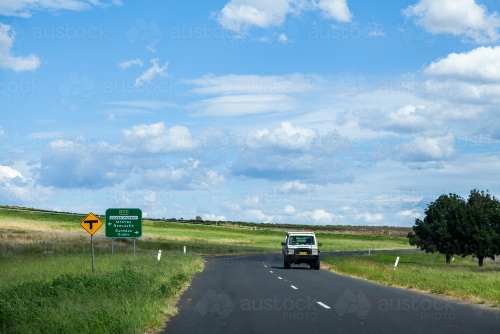 Road out of small country town with sign to Merriwa, Newcastle, Dunedoo and Dubbo - Australian Stock Image