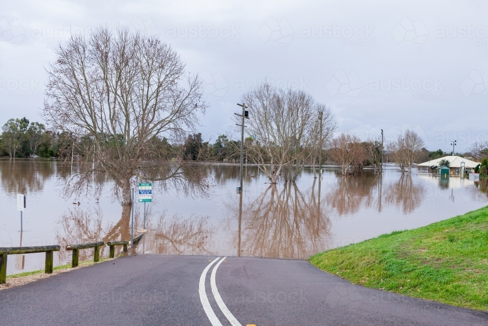 Road to park covered in floodwater during flooding natural disaster - Australian Stock Image