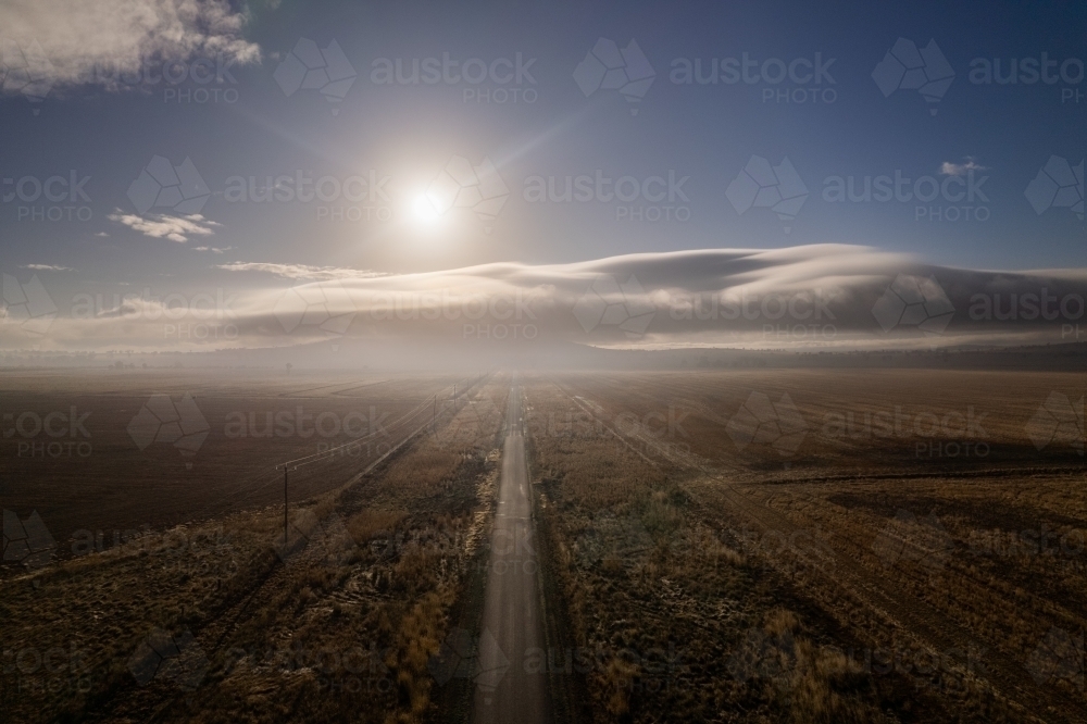 Road to the sky with the fog clouds coming through and the sun shining over the clouds - Australian Stock Image