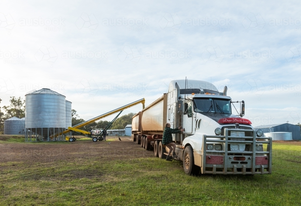 Road train loading grain from farm silos - Australian Stock Image