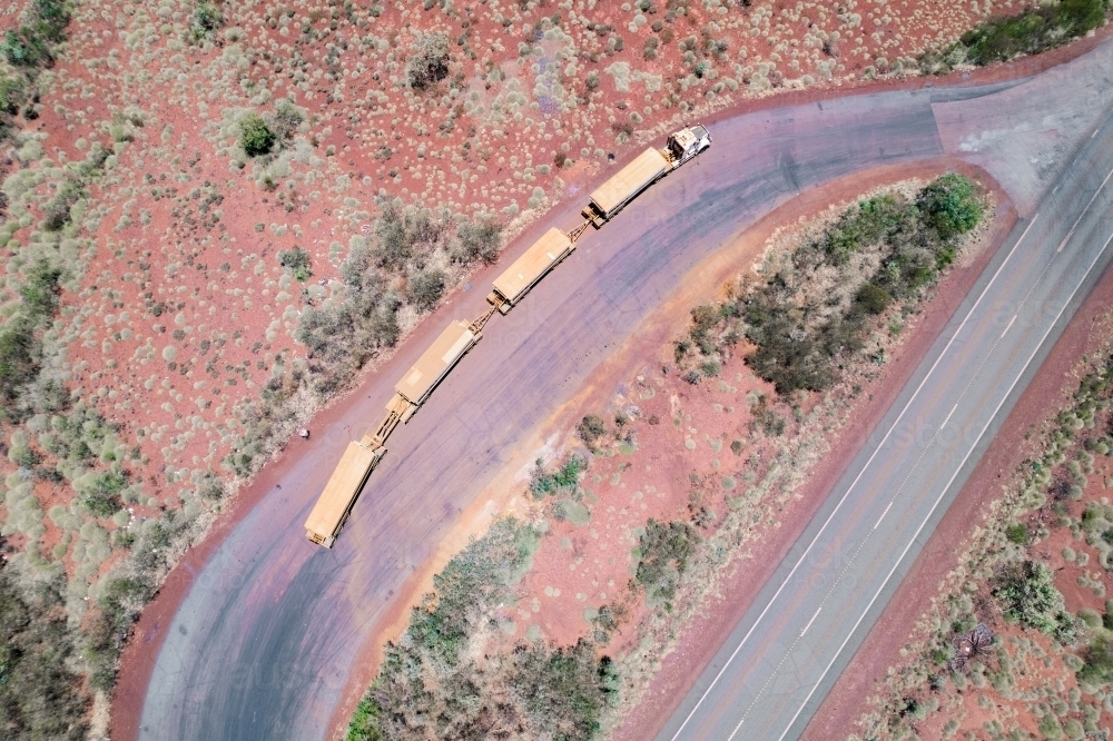 Road train stopped at a truck resting area next to the asphalt road - Australian Stock Image
