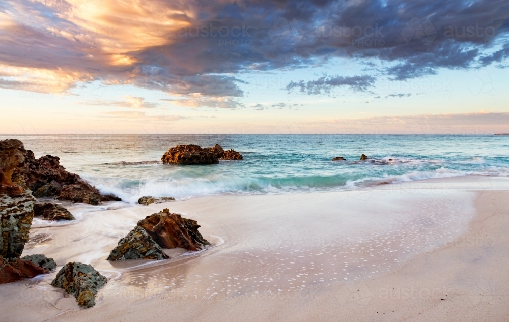 rocks and beach at sunrise - Australian Stock Image