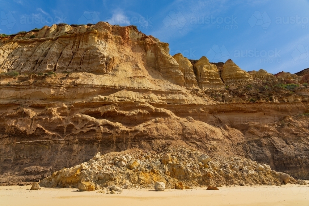 Rocks and rubble at the base of a coastal cliff face after a landslide - Australian Stock Image