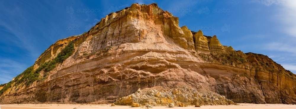 Rocks and rubble at the base of a coastal cliff face after a landslide - Australian Stock Image