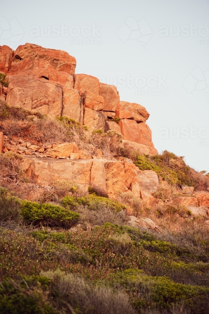 Rocky cliff view of rugged coastline at sunset - Australian Stock Image