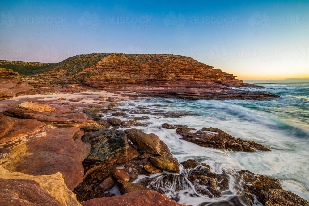 Rocky terrain along the coastline during dusk. - Australian Stock Image