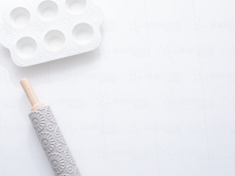 Rolling pin and muffin dish on blank background - Australian Stock Image