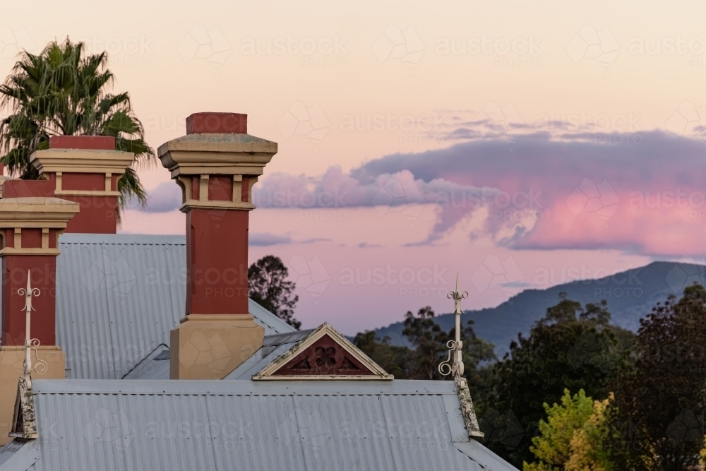 Rooftop of the historic Mudgee Railway Station with pink and purple twilight sky - Australian Stock Image