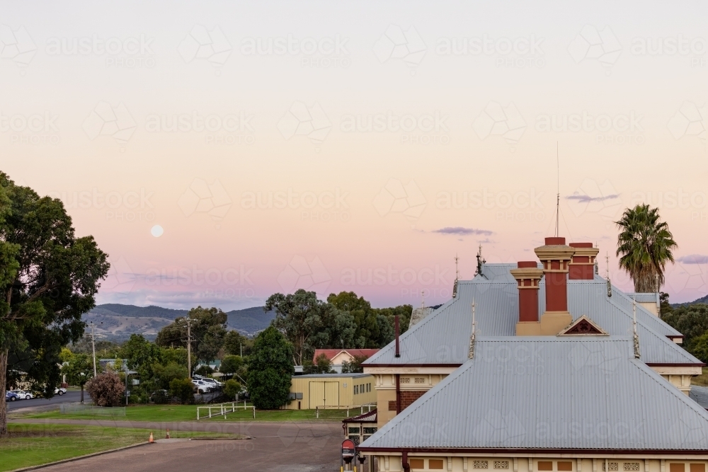 Rooftop of the historic Mudgee Railway Station with pink and purple twilight sky - Australian Stock Image