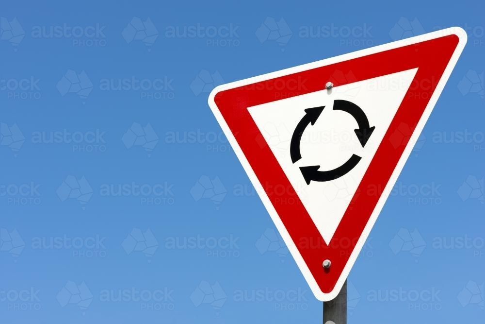 Roundabout sign against clear blue sky - Australian Stock Image