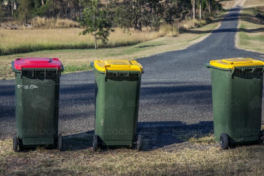 Rubbish and recycling bins waiting for collection beside a rural road - Australian Stock Image