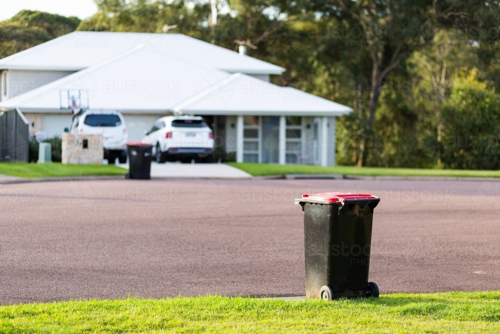 Rubbish bin awaiting collection on suburban curb side - Australian Stock Image