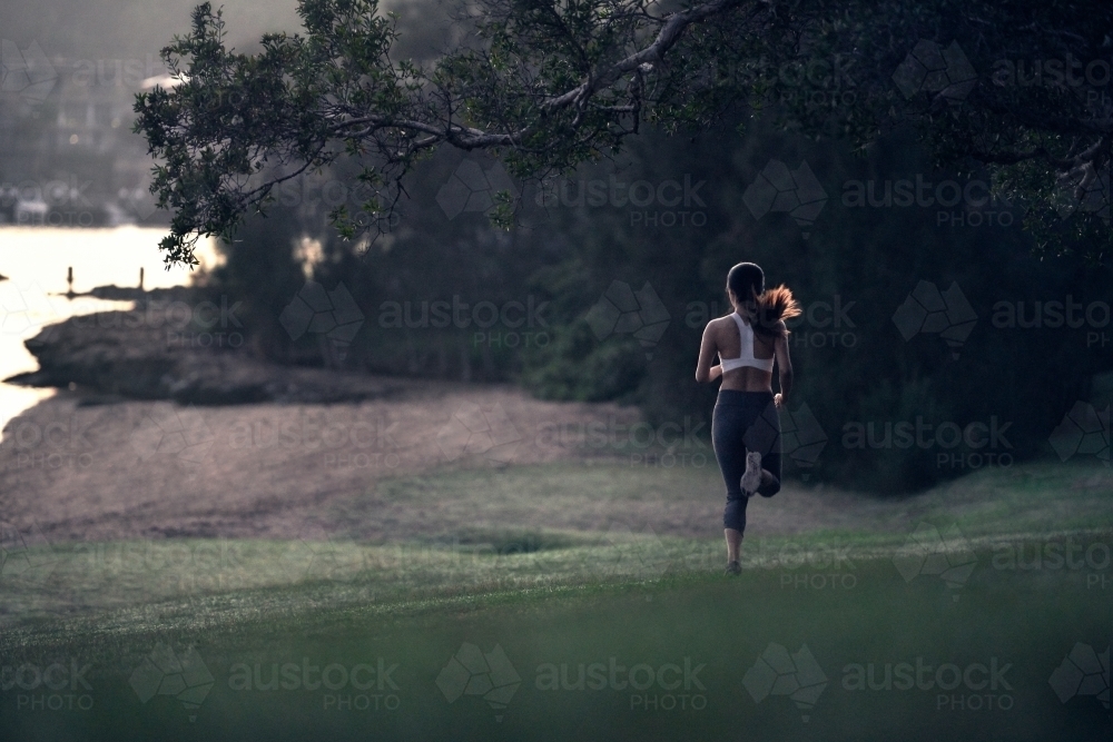 Runner running through a park for morning exercise - Australian Stock Image