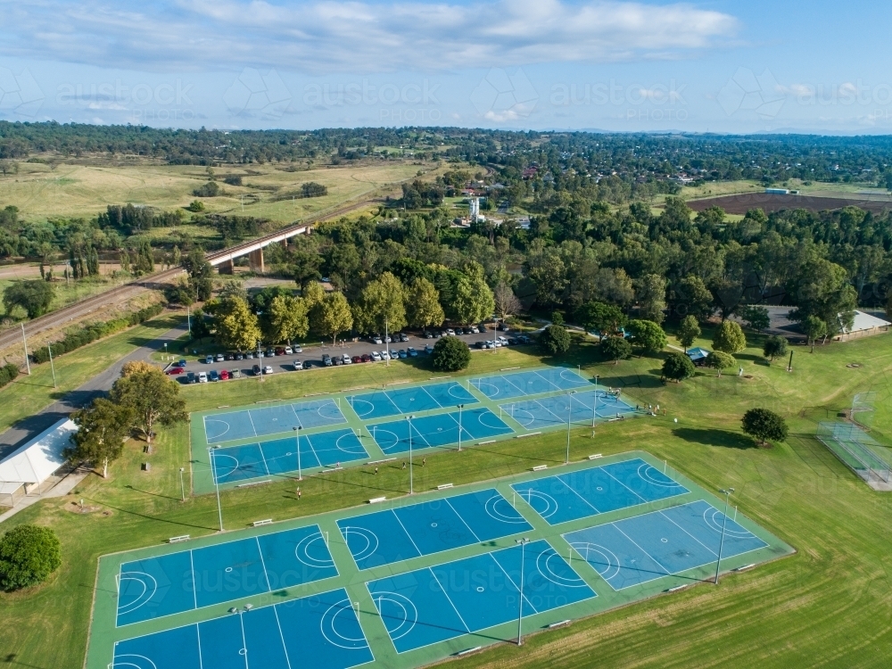 Runners arriving back to the end of Singleton parkrun through netball courts at Rose Point park - Australian Stock Image