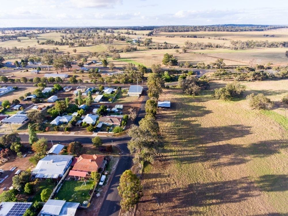 rural landscape showing houses on outskirts of small town and farmland - Australian Stock Image