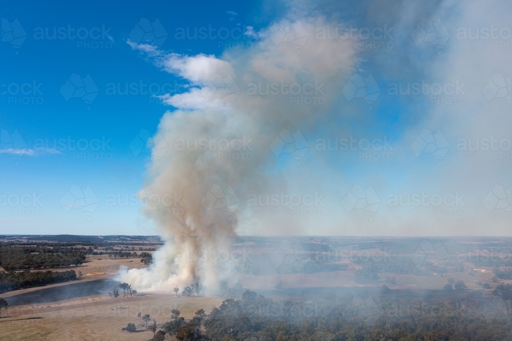 rural landscape with smoke rising from dry farmland - Australian Stock Image