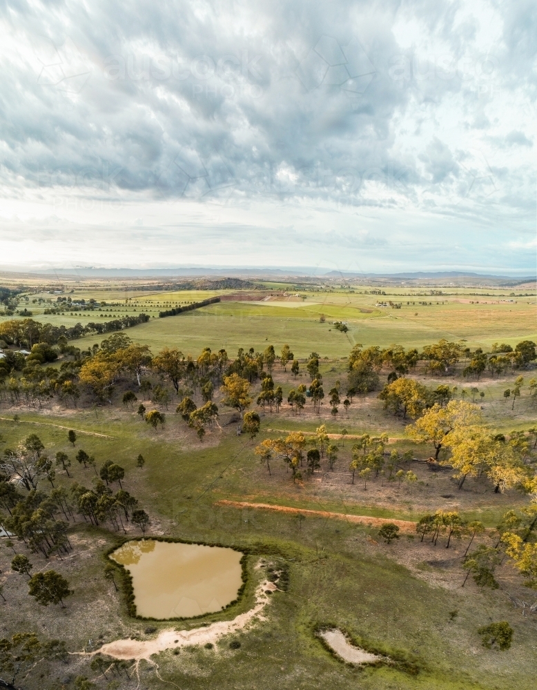 Rural paddock with large dam full of muddy water and small dry empty dam - Australian Stock Image