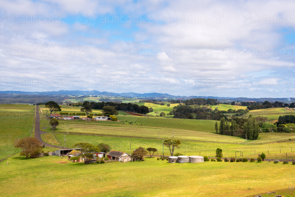 Rural valley landscape with farm buildings and hills in the distance, Tasmania - Australian Stock Image