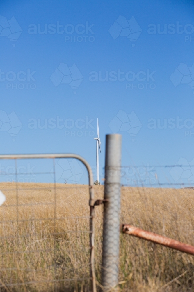 Rural Wind Turbines in a farm setting with a gate in foreground - Australian Stock Image