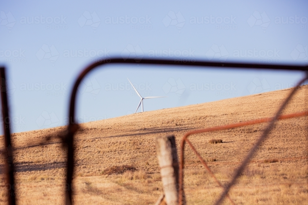 Rural Wind Turbines in a farm setting with a paddock gate in foreground - Australian Stock Image