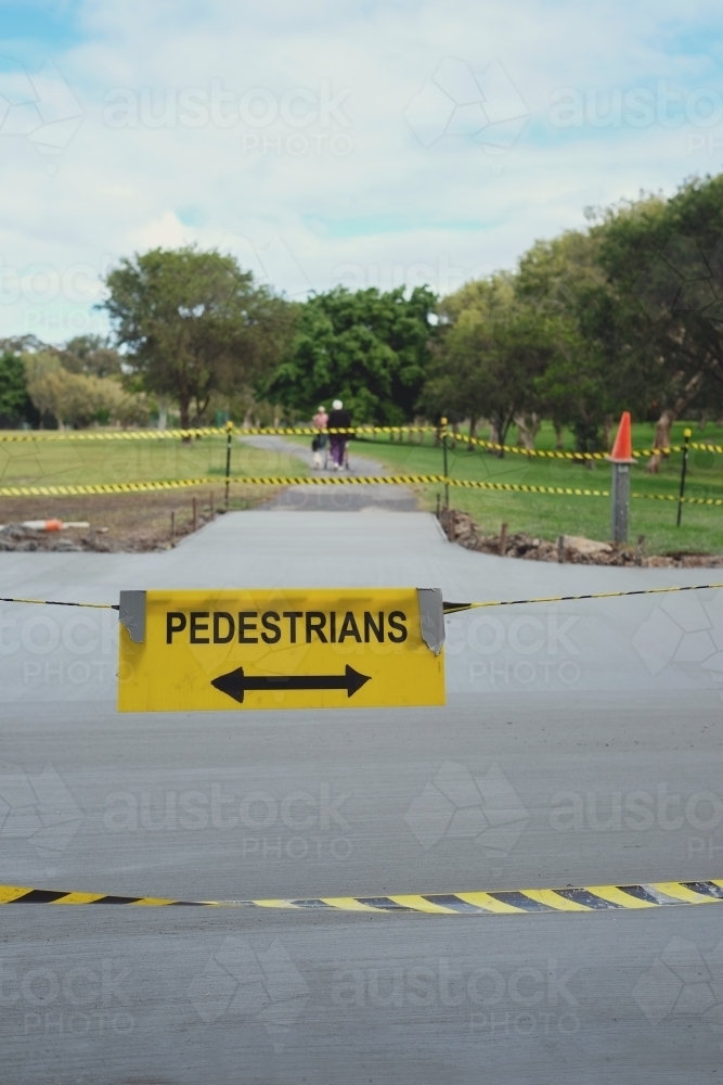 Safety black and yellow tape with pedestrians sign at the park - Australian Stock Image