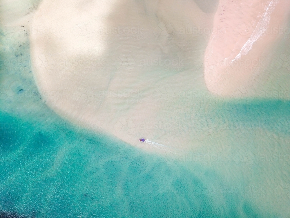 Sand Bar and blue water with a small boat - Australian Stock Image