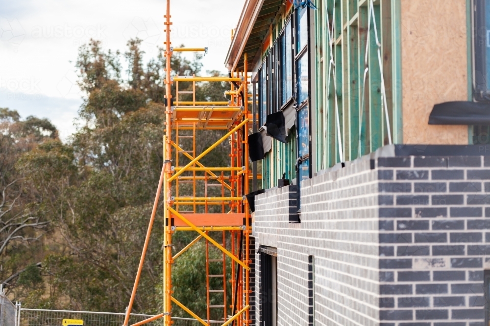 Scaffolding up around double storey new house build on construction site - Australian Stock Image