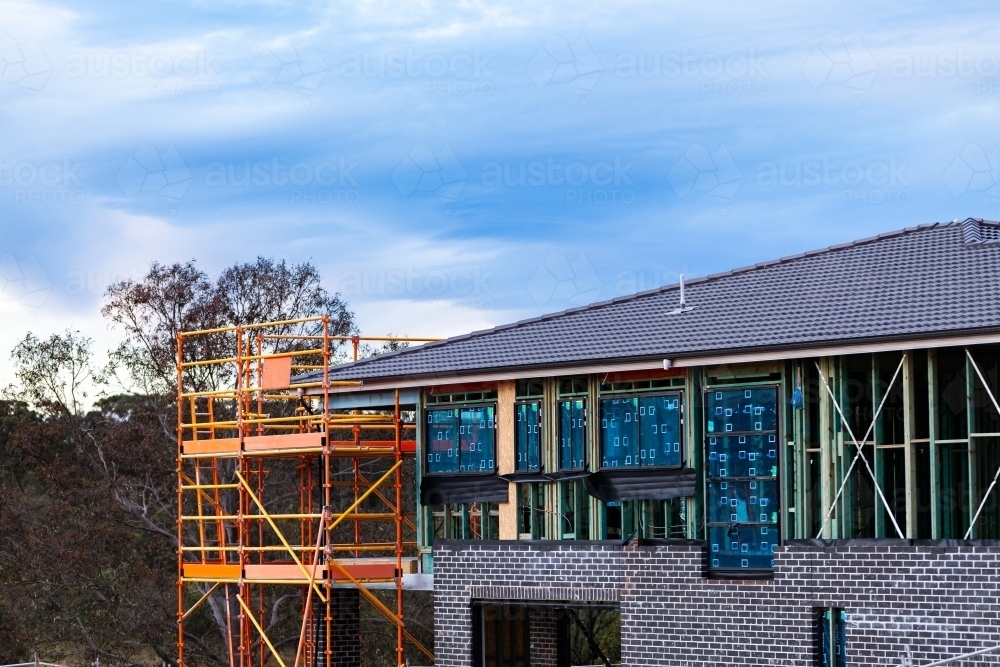 Scaffolding up around double storey new house build on construction site - Australian Stock Image