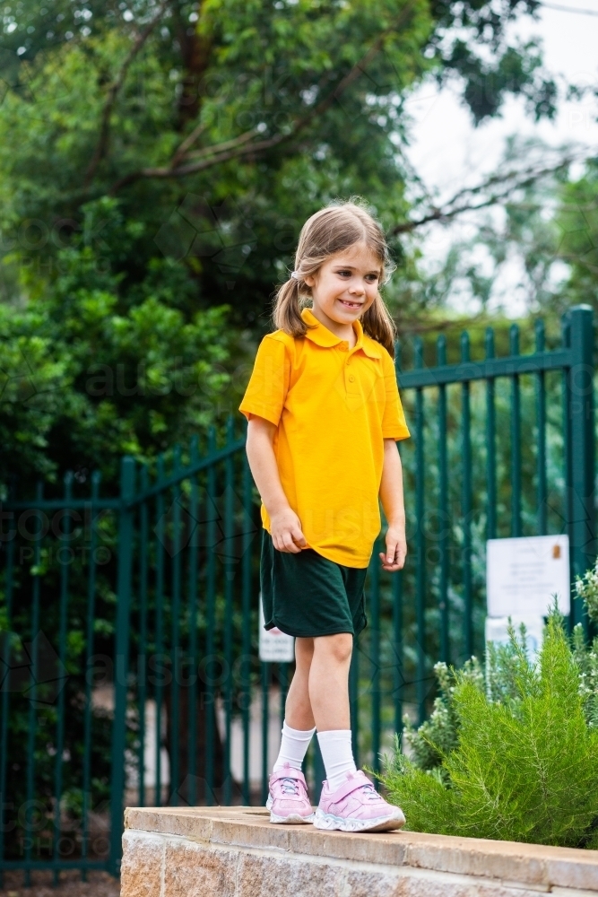 school kid balancing on brick wall - Australian Stock Image