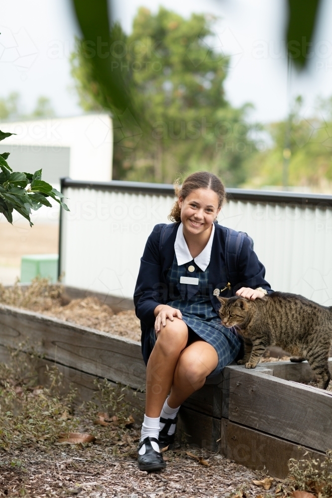 schoolgirl in uniform with her pet cat - Australian Stock Image