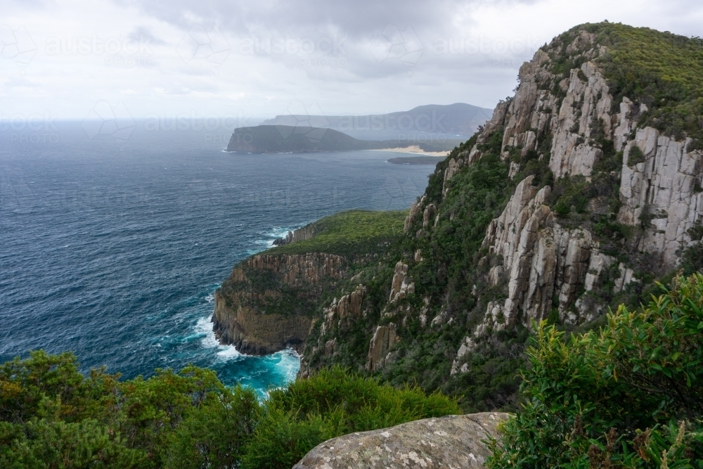 Sea spray haze over cliffs on Tasman Peninsula coastline - Australian Stock Image