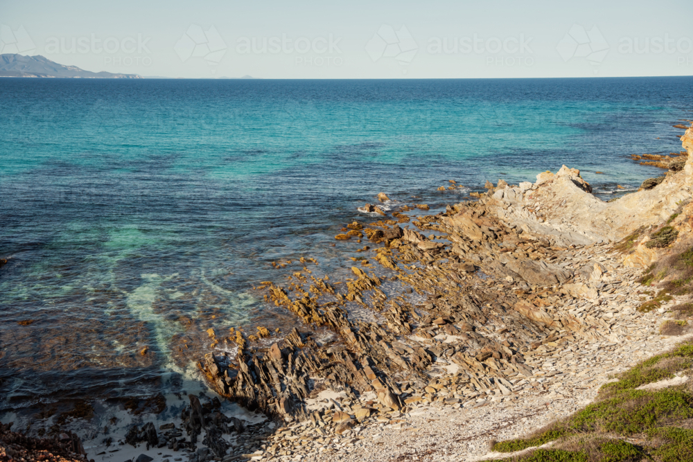 Seascape of rocky shoreline and blue water - Australian Stock Image